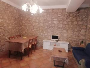 a living room with a table and a computer on a stone wall at Al Carpine in Roccadaspide