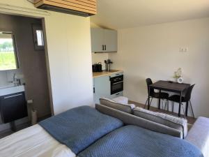 a bedroom with a couch and a table and a kitchen at Mariafarm Chalets in Zevenbergen +21 photos