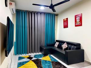 a living room with a black couch in front of a window at AARON MARUDU HOMESTAY in Kampong Sorosob
