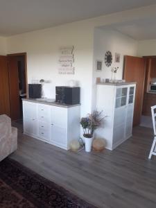 a living room with white cabinets and a kitchen at Ferienwohnungen Sternenhimmel WHG 1 in Medebach +55 photos