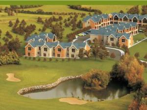 ein großes Haus auf einem Golfplatz mit Teich in der Unterkunft 3 Bedroom House 03 In Famous Esker Hills Golf Resort in Tullamore