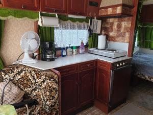 a kitchen in an rv with a counter and a fan at Ekebacken Gård & Mc-camping in Blidsberg