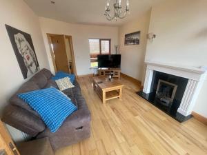 ein Wohnzimmer mit Couch und Kamin in der Unterkunft 3 Bedroom House 03 In Famous Esker Hills Golf Resort in Tullamore