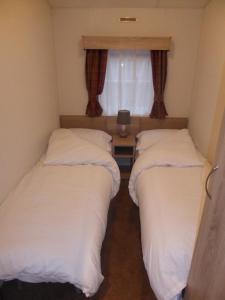 GlendevonにあるLewis Lodgeの窓付きの小さな部屋のベッド2台
