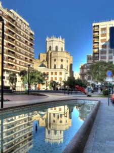 eine Spiegelung einer Kirche in einem Wasserbecken in der Unterkunft Atico céntrico espectacular y cerca de la playa in Castellón de la Plana