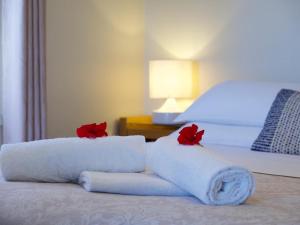 巴林巴林尔普海维欧木屋的床上有两条毛巾，上面有红玫瑰