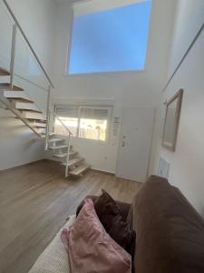 Una sala de estar con un sofá y una escalera. en Eco Home Gran Alacant, en Puerto Marino