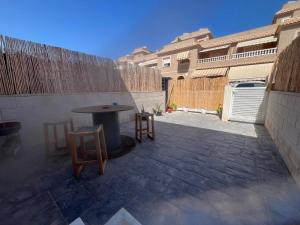 Un patio con mesa y sillas y una valla. en Eco Home Gran Alacant, en Puerto Marino