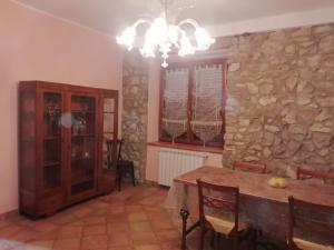 a dining room with a table and a stone wall at Al Carpine in Roccadaspide