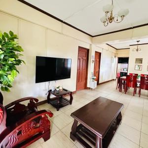 un soggiorno con TV a schermo piatto e tavolo di Near Tourist Spots Vacation House a Baguio Altre 3 foto