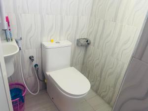 a bathroom with a white toilet and a sink at Triple s homes in Arusha +34 photos