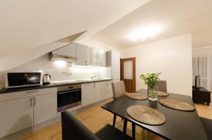 a kitchen and dining room with a table and chairs at Pension Zličín in Prague