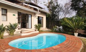a swimming pool in front of a house at King's Hill Guest House in Hilton