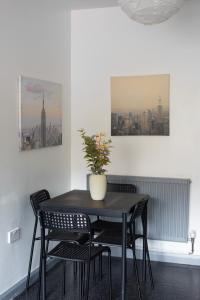 a black dining room table with chairs and a vase on it at Well-equipped 4 Bedroom House close to City Centre in Leeds