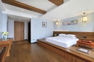 阳朔Xianchuang landscape Garden Hotel Yangshuo West Street Lijiang River的卧室里有一张白色的大床和一张书桌