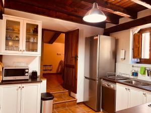 a kitchen with a stainless steel refrigerator and white cabinets at Villa Revolcona in La Adrada