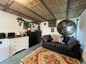a living room with a couch and a kitchen at Cromford Garden Glamping Hut Peak District in Cromford