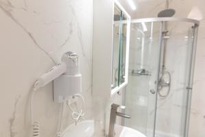 a bathroom with a blow dryer on the wall at Apartamenty Ogrodowa in Zielona Góra