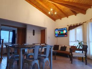 a dining room with a table and chairs and a tv at Las Condalias in Puerto Madryn