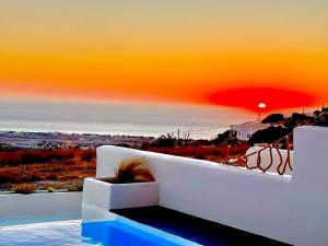 a view of the ocean from a white couch at Salida Del Sol Santorini in Éxo Goniá