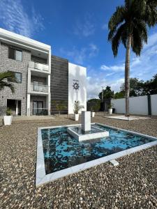 a house with a fountain in front of a building at Level suites Penthouse in Sosúa