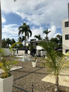 a courtyard with palm trees and a building at Level suites Penthouse in Sosúa