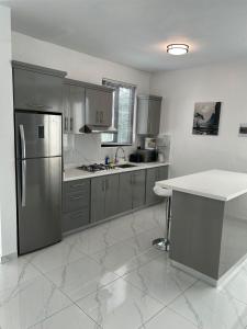 a kitchen with a stainless steel refrigerator and a table at Level suites Penthouse in Sosúa