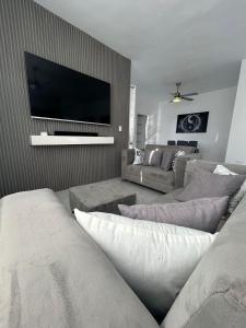 a living room with a couch and a flat screen tv at Level suites Penthouse in Sosúa