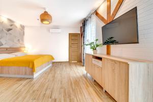 a bedroom with a bed and a flat screen tv at Apartamenty Grodowa 2 in Gliwice