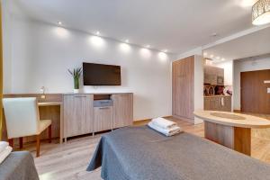 a room with a bed and a flat screen tv at Apartamenty Grodowa 2 in Gliwice