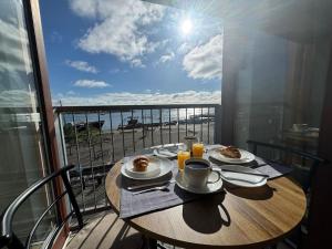 a table on a balcony with a view of the ocean at Key West Suites in Wexford