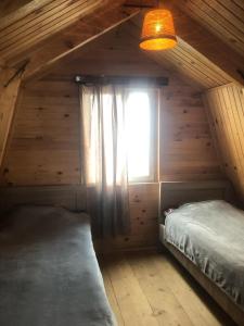 GomiCloudtop hut的小木屋内一间卧室,带窗户