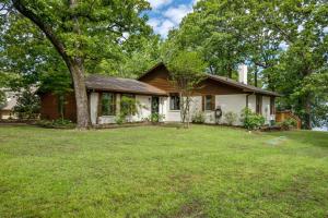 een klein wit huis met een boom in een tuin bij Lakefront Cottage- late summer price decrease! in Pittsburg