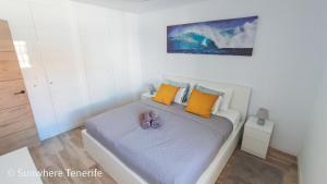a bedroom with a bed with two shoes on it at Cozy apartment with wonderful view - Los Cristianos in Arona +22 photos