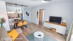 a living room with a couch and a tv and a table at Cozy apartment with wonderful view - Los Cristianos in Arona