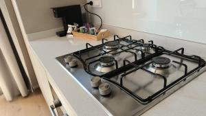 a stove top with four pots on it in a kitchen at Pep's Rooms by the sea in Trieste