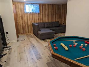 a living room with a pool table and a couch at Peaceful and Heavenly Private Water Front Cottage on 100 Acres of Scenic Beauty- Trent Lakes in Kinmount