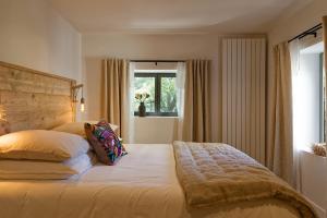 a bedroom with a large bed and a window at Maison Paulette in Eygalières