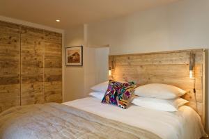 a bedroom with a large bed with a wooden headboard at Maison Paulette in Eygalières
