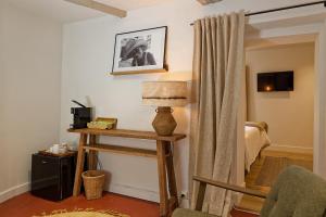 a room with a bed and a table with a lamp at Maison Paulette in Eygalières