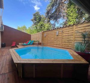 a swimming pool on a deck with a wooden fence at Superbe Villa avec piscine, 4 chambres à Vinassan in Vinassan