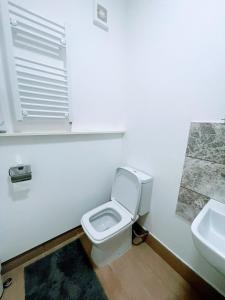 a white bathroom with a toilet and a sink at Bay Wind Apartment in Morecambe
