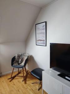 un soggiorno con sedia e TV di 2vær lejlighed - Dronninglund a Dronninglund