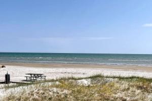 un tavolo da picnic su una spiaggia vicino all'oceano di 2vær lejlighed - Dronninglund a Dronninglund