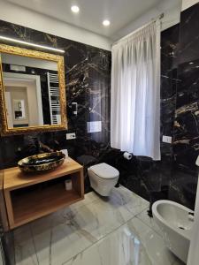 Un baño con inodoro, lavabo y espejo. en B&B AIDA Rooms Cefalù, en Cefalú 96 fotos más
