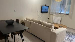 un soggiorno con un divano, un tavolo e una TV di Dream appartement!! spacieux ,calme au rez-de-chaussée a Bourg-en-Bresse Altre 2 foto