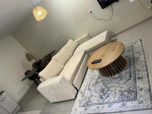 un soggiorno con divano bianco e tavolo in legno di Dream appartement!! spacieux ,calme au rez-de-chaussée a Bourg-en-Bresse