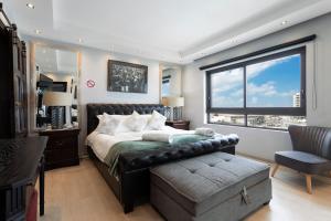 a bedroom with a bed and a large window at Luxury Beachfront 706 with AC, Workspace & Table Mountain Views in Cape Town