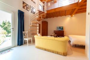 a living room with a yellow couch and a bed at Florence Villa Violetta in Bagno a Ripoli