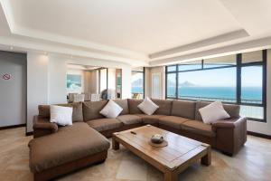 a living room with a couch and a coffee table at Luxury Beachfront 706 with AC, Workspace & Table Mountain Views in Cape Town